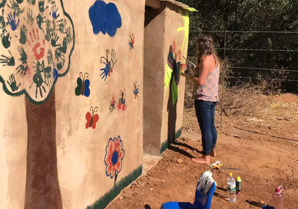 Freiwillige bemalen eine Wand in ihrem Projekt