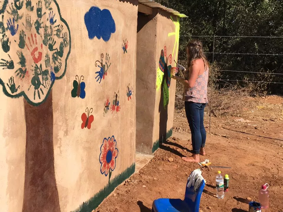 Freiwillige bemalen eine Wand in ihrem Projekt